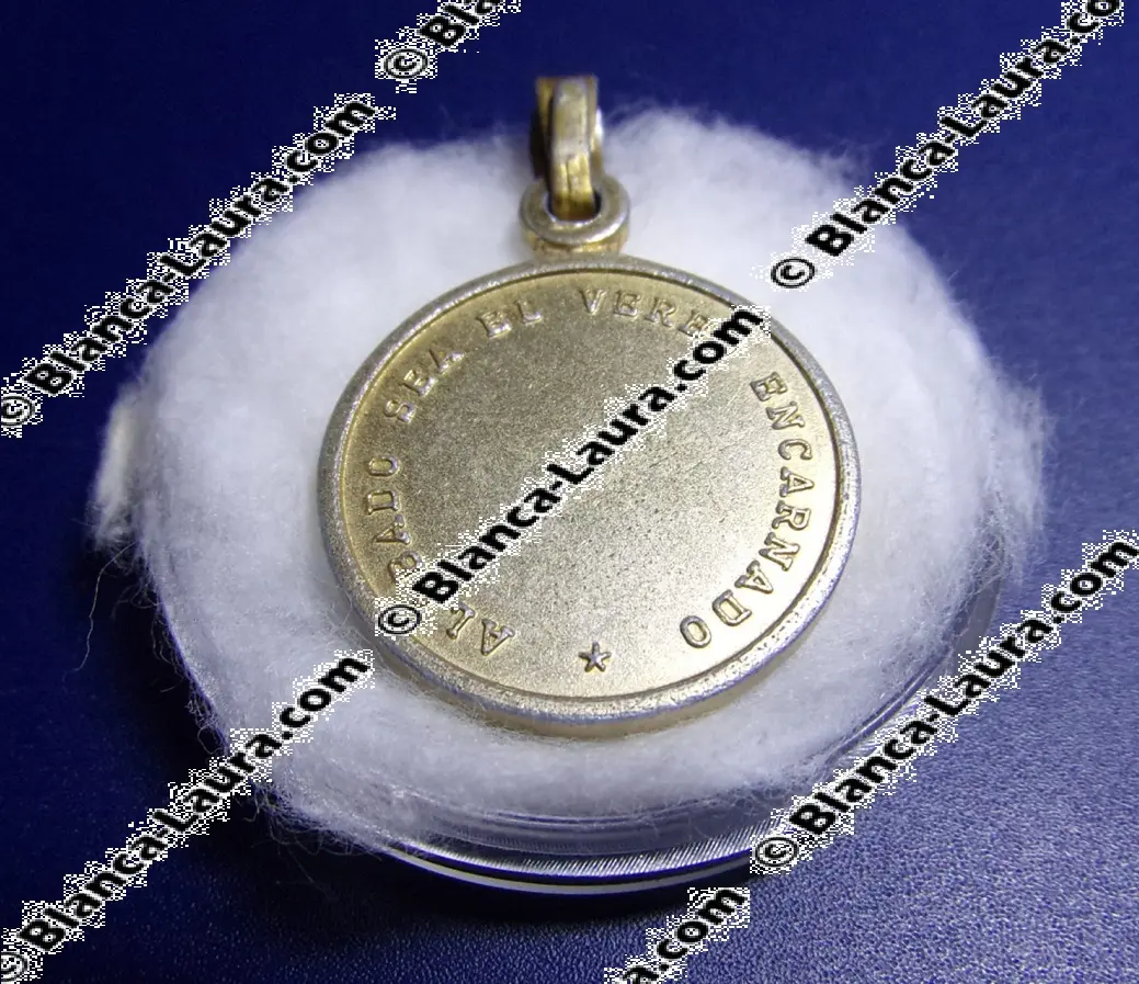 The Back of the Medal with the Inscription Praised be the Incarnate Word in Spanish.